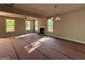 Spacious living room featuring a cozy fireplace, ceiling fan, and light fixture at 136 Asa Moseley Rd, Mcdonough, GA 30252