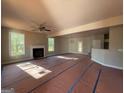 Bright living room with fireplace, ceiling fan, and large windows offering lots of natural light at 136 Asa Moseley Rd, Mcdonough, GA 30252