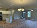 Bright, open space featuring a modern light fixture and a view of the staircase and front door at 136 Asa Moseley Rd, Mcdonough, GA 30252
