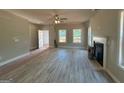 Open living room features new floors, a ceiling fan, a fireplace and large windows overlooking the yard at 148 Asa Moseley Rd, Mcdonough, GA 30252