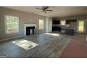Open-concept living room with modern flooring, a fireplace, and lots of natural light at 148 Asa Moseley Rd, Mcdonough, GA 30252