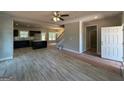 Open layout features new floors, a ceiling fan, fireplace, kitchen, and a staircase at 148 Asa Moseley Rd, Mcdonough, GA 30252