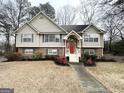 Two-story house with brick and siding exterior, landscaped lawn, and walkway, red front door at 1134 Wagon Trce, Douglasville, GA 30134