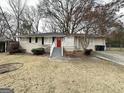Brick ranch home with a red door, landscaping, and a driveway at 6419 Katherine St, Douglasville, GA 30134