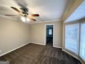 Bright living room with neutral carpeting, bay window, and ceiling fan at 6419 Katherine St, Douglasville, GA 30134