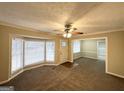 Spacious living room with neutral carpeting, bay window and ceiling fan at 6419 Katherine St, Douglasville, GA 30134