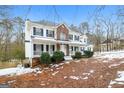 Two-story house with brick and white siding, porch, and landscaping in winter at 380 River Point Dr, Mcdonough, GA 30252