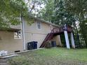 Back exterior view of home with wooden deck, stairs, and wooded backyard at 3746 Chapel Hill Road, Douglasville, GA 30135