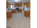Kitchen with wood cabinets, stainless steel appliances, and light flooring at 3590 Stephens Creek Pl, Loganville, GA 30052