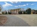 Elegant brick home featuring stately columns and a circular driveway; Southern charm at its finest at 1909 Hickory Level Rd, Villa Rica, GA 30180