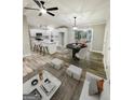 Bright living room with an open layout to kitchen and dining, featuring hardwood floors, island seating, and modern furnishings at 663 Airport Rd, Oxford, GA 30054