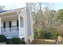 Grey home exterior with white trim, black shutters, chimney, front porch and yard at 3013 Pommel Ct, Conyers, GA 30013
