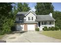 Charming two-story home featuring a two-car garage, brick accents, and a cozy front porch at 3013 Pommel Ct, Conyers, GA 30013
