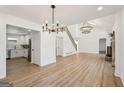 Open-concept living room with hardwood floors, modern light fixtures, and stairs to second floor at 3939 Hamilton Mill Rd, Buford, GA 30519