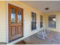 Inviting front porch with rocking chairs and a wood door at 130 Seneca Pl, Fayetteville, GA 30215