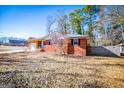 Brick ranch house with attached garage and mature trees at 653 Temple St, Lithia Springs, GA 30122