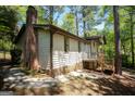 Home exterior showing the siding, brick chimney, and a small porch with wooden railings at 60 Sweet Bay Ln, Carrollton, GA 30116