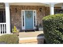 Charming front entrance with stone accents, a welcoming blue door, and a decorative wreath at 4780 Rambling Rose Dr, Cumming, GA 30040