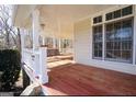 Spacious front porch with wooden swing and railing at 1885 Jenny Ln, Lithia Springs, GA 30122