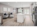 Bright, open-concept kitchen features an island, stainless steel appliances, and hardwood floors at 2070 Fortuna St, Lawrenceville, GA 30046