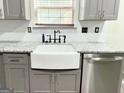 Stylish kitchen with a large white farmhouse sink, stainless steel dishwasher, and granite countertop at 775 Georgetown Ln, Jonesboro, GA 30236