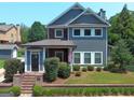 Charming two-story home featuring a cozy front porch, manicured shrubbery, and an American flag at 10 Plum Blossom Ln, Hampton, GA 30228