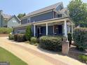 Gray sided two-story home with wrap around porch and landscaping at 10 Plum Blossom Ln, Hampton, GA 30228