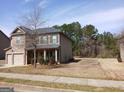 Charming two-story home with a stone and siding facade, attached garage and landscaped yard at 284 Madison Grace Ave, Mcdonough, GA 30252