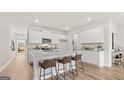 Bright kitchen features a spacious island with bar seating, granite countertops, and modern stainless-steel appliances at 317 Sound Cir # 139, Stockbridge, GA 30281