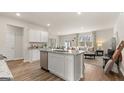 Open-concept kitchen includes an island with granite countertops that overlooks a cozy living area, with modern fixtures at 317 Sound Cir # 139, Stockbridge, GA 30281