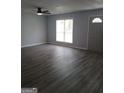 Spacious living room with grey wood-look flooring and a large window at 1059 Garibaldi Sw St, Atlanta, GA 30310