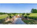 View of the property's entrance with a gated driveway, mature trees, and a meticulously landscaped approach at 3170 Double Bridges Rd, Rutledge, GA 30663