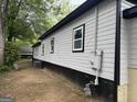 Side exterior view of gray home with black trim and utility access at 1771 Ware Ave, East Point, GA 30344