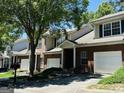 Townhouse exterior with brick facade, attached garage, and mature trees at 2567 Laurel Nw Cir, Atlanta, GA 30311
