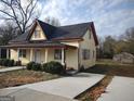 Inviting yellow house with a covered porch and a long driveway at 41 W Main St, Hampton, GA 30228