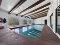 A bright and inviting indoor pool with wooden ceiling beams and a tile border is ready for swimming year-round at 107 Stratford Ct, Peachtree City, GA 30269