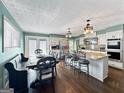 An open-concept kitchen with white cabinetry, stainless steel appliances, and a breakfast bar looks bright and spacious at 107 Stratford Ct, Peachtree City, GA 30269