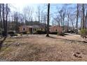 Ranch home with neutral siding, white trim, and a yard with mature shrubs and trees at 125 Oak Leaf Dr, Stockbridge, GA 30281