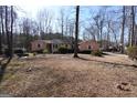 Ranch home with neutral siding, white trim, and a yard with mature shrubs and trees at 125 Oak Leaf Dr, Stockbridge, GA 30281