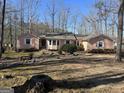 Ranch home with neutral siding, white trim, and a yard with mature shrubs and trees at 125 Oak Leaf Dr, Stockbridge, GA 30281