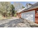Side view of brick home featuring an attached garage at 25 Brookstone Ct, Covington, GA 30016