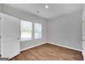 Simple bedroom with wood-look floors and two windows at 5316 Tolar Rd # 24, South Fulton, GA 30213