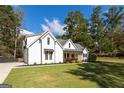 Beautiful two-story home with an expansive lawn, black trim windows, and a welcoming front porch at 9770 Coleman Rd, Roswell, GA 30075