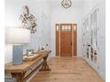Light-filled foyer featuring hardwood floors, a wooden bench, and a craftsman-style front door at 9770 Coleman Rd, Roswell, GA 30075