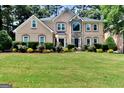 Tan house with stone accents, landscaping, and large yard at 4335 Burgomeister Pl, Snellville, GA 30039