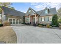 Green house with stone accents, two-car garage, and manicured lawn at 8445 Nolandwood Ln, Villa Rica, GA 30180