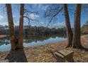 Serene lakeside view with bench; peaceful and picturesque setting at 8445 Nolandwood Ln, Villa Rica, GA 30180