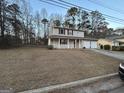 View of the front elevation showing a spacious lot, covered front porch and two-car garage at 5427 Forest Pines Dr, Lithonia, GA 30058