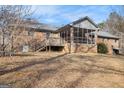 Backyard view of the brick home with a deck and screened in porch at 255 Barnett Road Rd, Hampton, GA 30228