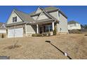 Home exterior featuring complementary stone veneer, neutral siding, and a manicured lawn at 1455 Weeping Tree Cir, Auburn, GA 30011